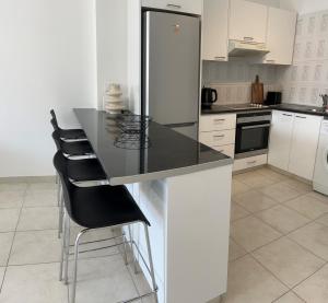a kitchen with a black counter and a refrigerator at Costa Del Ray in Paphos