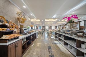 a bakery with a long row of counters and tables at Golden Lotus Luxury Hotel Danang in Da Nang