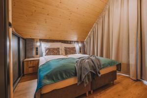 Bett in einem Zimmer mit Holzdecke in der Unterkunft Słone Wzgórze in Rabka-Zdrój