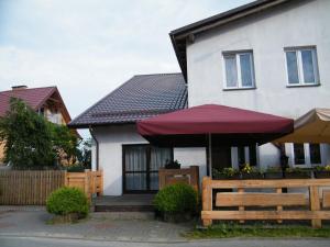 a house with a red umbrella and a wooden fence at DOM KĄCIK in Kąty Rybackie