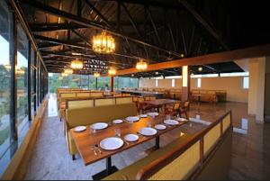 a restaurant with a long table with plates on it at Lake Valley Resort and Spa Tirupati, 27 kms from Talakona Waterfall in Tirupati