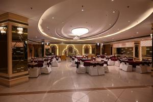 a banquet hall with tables and chairs in a building at Deventure Hotel, Karnal in Karnal