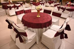 a table and chairs in a room with red and white at Deventure Hotel, Karnal in Karnal