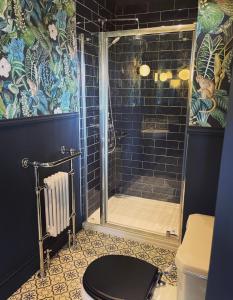 a bathroom with a shower with a toilet and a sink at No.123 The Old Post House in Scalby