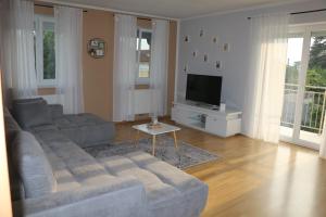 een woonkamer met een bank en een tv bij Vienna's Cozy Corner - charming familiy apartment in Gerasdorf bei Wien