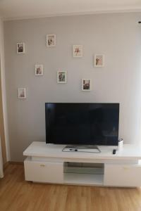 a white entertainment center with a flat screen tv at Vienna's Cozy Corner - charming familiy apartment in Gerasdorf bei Wien