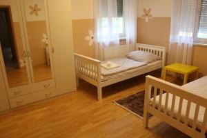 a small room with two cribs and a mirror at Vienna's Cozy Corner - charming familiy apartment in Gerasdorf bei Wien
