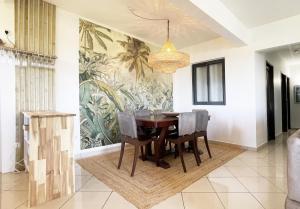 une salle à manger avec une table et des chaises ainsi qu'une fresque murale. dans l'établissement L'Air Sauvage * * * Bassin de Manapany, à Saint-Joseph