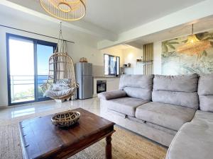 uma sala de estar com um sofá e uma mesa em L'Air Sauvage * * * Bassin de Manapany em Saint-Joseph