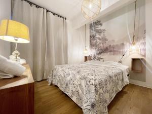1 dormitorio con 1 cama, 1 lámpara y 1 pintura en L'Air Sauvage * * * Bassin de Manapany, en Saint-Joseph