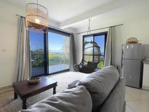 un soggiorno con divano e una grande finestra di L'Air Sauvage * * * Bassin de Manapany a Saint-Joseph