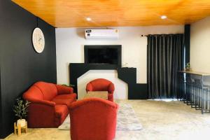 ein Wohnzimmer mit 2 Stühlen und einem Kamin in der Unterkunft Forest Hill Resort in Chanthaburi