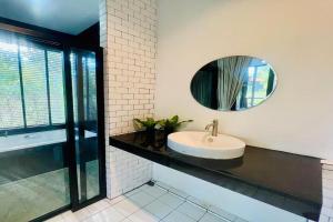 a bathroom with a sink and a mirror at Forest Hill Resort in Chanthaburi