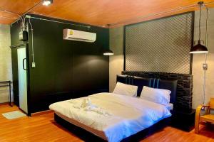 a bedroom with a large bed with a black headboard at Forest Hill Resort in Chanthaburi