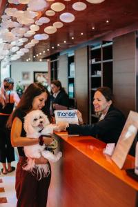 a woman holding a dog at a store counter at Hotel Adlon in Lido di Jesolo