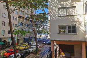 una vista de una calle con coches estacionados en el lateral de un edificio en Apartamento econômico e espaçoso para 6 pessoas, en Río de Janeiro