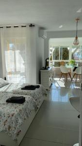 um quarto branco com uma cama, uma mesa e cadeiras em Las Palmeras em Algarrobo