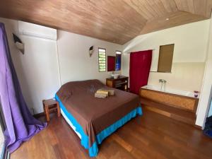 茉莉亞的住宿－Moorea Temae Villa walking dist beach and golf，一间卧室配有一张床、一个浴缸和一个水槽