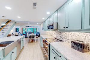 eine Küche mit blauen Schränken und einem Esszimmer in der Unterkunft Sailmaster Commons, Unit 16 in Hilton Head Island