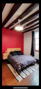 a bedroom with a bed and a red wall at 101 Studio en plein cœur historique de Bourges in Bourges