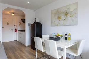 een eetkamer met een witte tafel en witte stoelen bij Sunny Studio - Only 5-Min Walk to Sea & Dunes in Wijk aan Zee