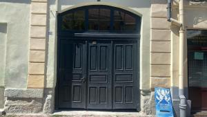 een zwarte deur in een stenen gebouw met een raam bij Bretsara in Bistriţa