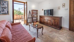 ein Wohnzimmer mit einem Sofa und einem Tisch mit einem TV in der Unterkunft CASA EUSEBIA 8&4, Emma VIllas in Città della Pieve