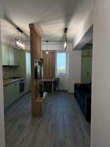 een keuken en een woonkamer met groene kasten en een tafel bij Green Residence in Suceava