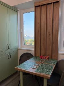 een eetkamer met een tafel en een raam bij Green Residence in Suceava