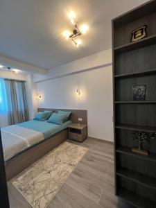 een slaapkamer met een bed en een boekenplank bij Green Residence in Suceava