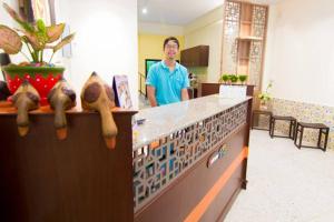 a man is standing at a counter in a lobby at K.L. Boutique Hotel in Krabi town