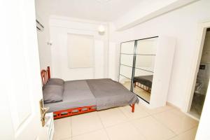 een witte kamer met een bed en een spiegel bij Wohnung mit Meerblick in Bodrum City