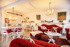uma sala de estar com mobiliário vermelho e uma sala de jantar em Die Kleine Oase em Stuhr