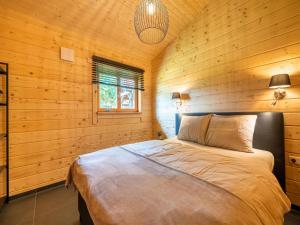 una camera con un letto su una parete in legno di Cozy holiday home in Limburg with a beautiful view a Schinnen