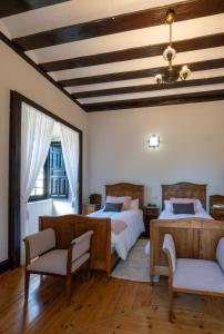 a bedroom with two beds and two chairs at La Posada de Pradorey in Ventosilla