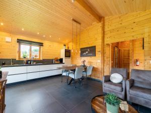 a kitchen and dining room in a wooden cabin at Cozy holiday home in Limburg with a beautiful view in Schinnen