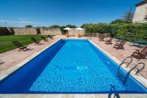 a blue swimming pool with chairs at La Posada de Pradorey in Ventosilla