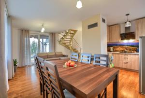 a kitchen and dining room with a wooden table and chairs at Panskiemisie Domki Całoroczne sauna jacuzzi in Wetlina