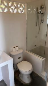 a white bathroom with a toilet and a sink at Yay Lodge SIARGAO, private room 1 with AC & hot shower and fast Starlink Wifi in General Luna