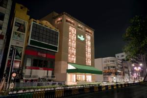 拉杰果德Lemon Tree Hotel, Rajkot的一座高大的建筑,有绿色屋顶,位于城市