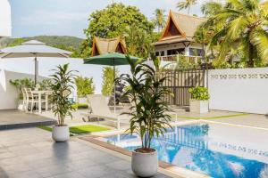 a villa with a swimming pool and a resort at Kamala - 2 BR Pool View Apartment in Kamala Beach