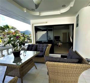 a living room with a table and chairs at Kamala - 2 BR Pool View Apartment in Kamala Beach