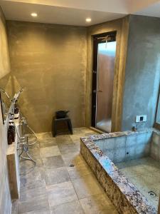 uma casa de banho com um chuveiro e uma banheira em Minato-no Akari em Hayama