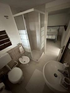 La salle de bains est pourvue de toilettes, d'un lavabo et d'une douche. dans l'établissement Appartamento sul Mare Fano, à Fano