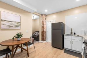 a kitchen with a table and a refrigerator at Peaceful Studio Flat near Downtown Mount Clemens in Mount Clemens