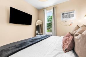 a bedroom with a large bed with a flat screen tv at Peaceful Studio Flat near Downtown Mount Clemens in Mount Clemens