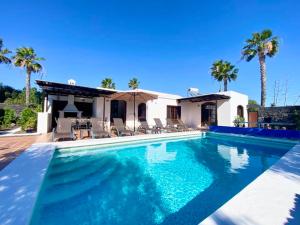 a swimming pool in front of a house with palm trees at VILLA ALICIA by JK Lanzarote in Puerto del Carmen