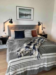 um quarto com uma cama com um cobertor em Bo med stil og udsigt til Aarhus lystbådehavn em Aarhus