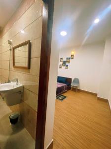 ein Bad mit einem Waschbecken und ein Bett in einem Zimmer in der Unterkunft Nhan Tay Hostel in Cần Thơ