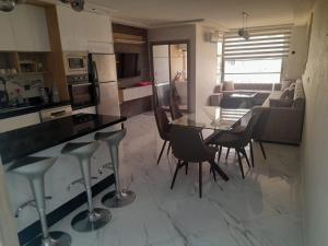 Appartement Wow في الحسيمة: مطبخ وغرفة معيشة مع طاولة وكراسي